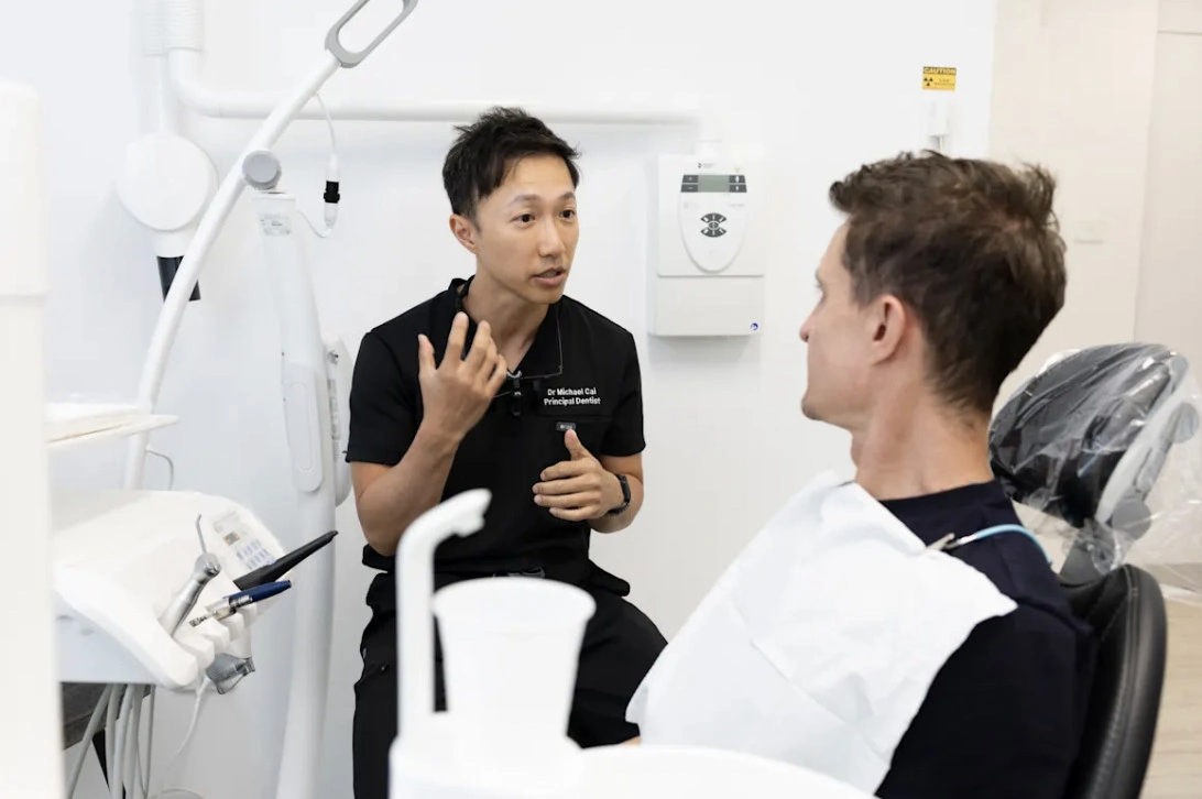 Dr Michael Cai speaks with patient Jean Carre before Carre’s teeth whitening.